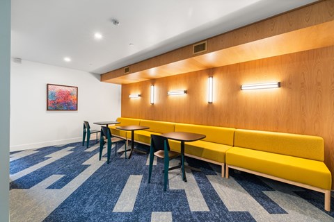 A room with a long bench and a table with chairs.