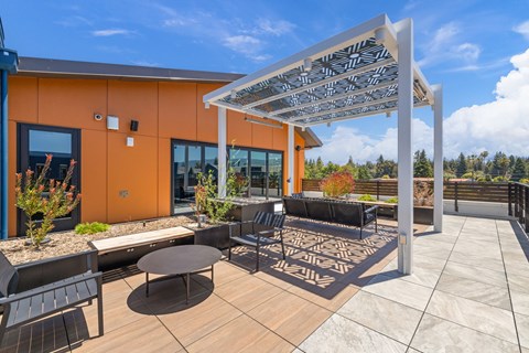 A patio with a table and chairs under a white awning.