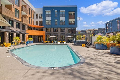 A swimming pool in a courtyard surrounded by buildings.