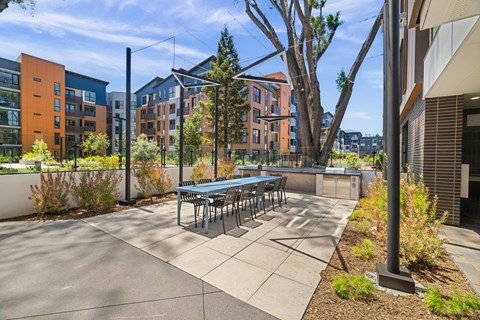 A patio with a table and chairs is surrounded by buildings.