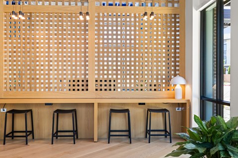 A wooden lattice panel with a lamp and four stools in front of it.