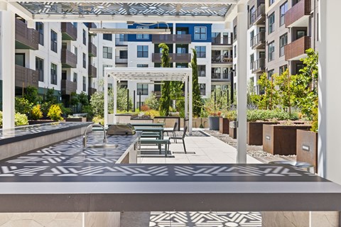 A patio with a table and chairs is surrounded by buildings.