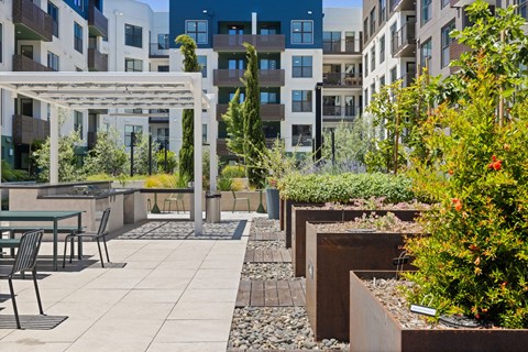 A patio with a table and chairs is surrounded by buildings.