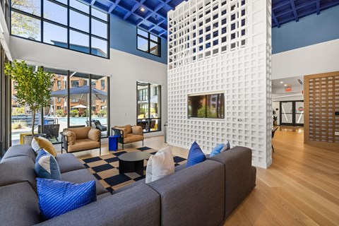 A living room with a white wall and a black and white checkered rug.