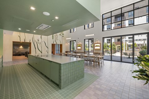 A green tiled kitchen island sits in the middle of a room with a large window.