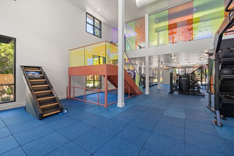 A gym with a blue floor and a yellow and orange structure in the middle.