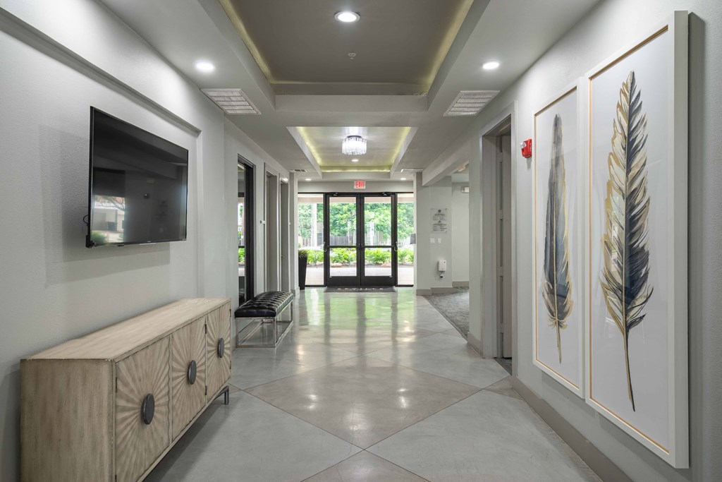 a hallway with a tv and a bench in front of a door
