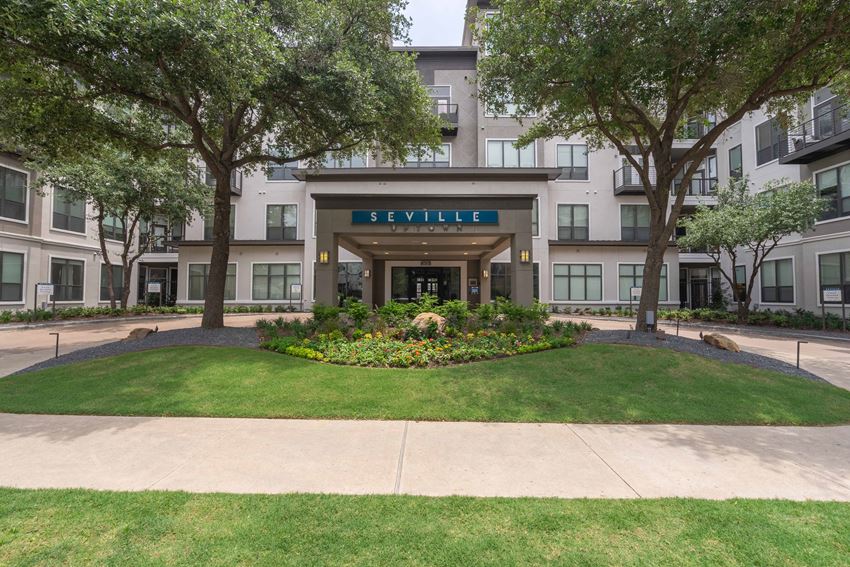 building entrance with a lawn and trees in front of it
