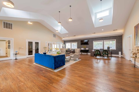 A spacious living room with a blue table in the center.