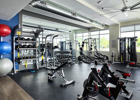 A gym with a variety of equipment including weights and cardio machines.