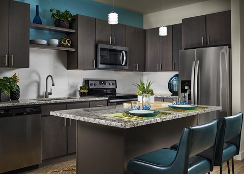 A modern kitchen with a table set for two.