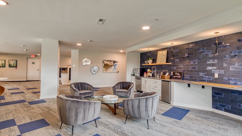 A living room with grey chairs and a blue rug.
