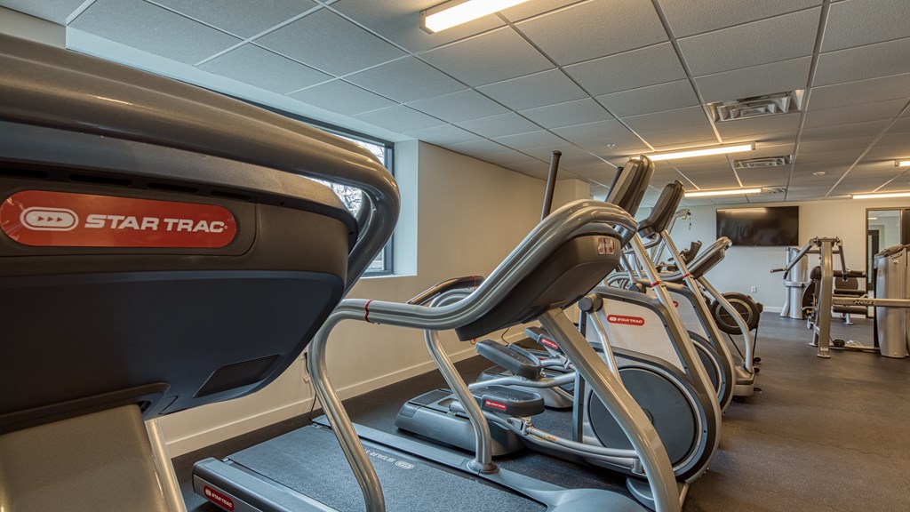 A Star Trac treadmill is in a gym with other treadmills.