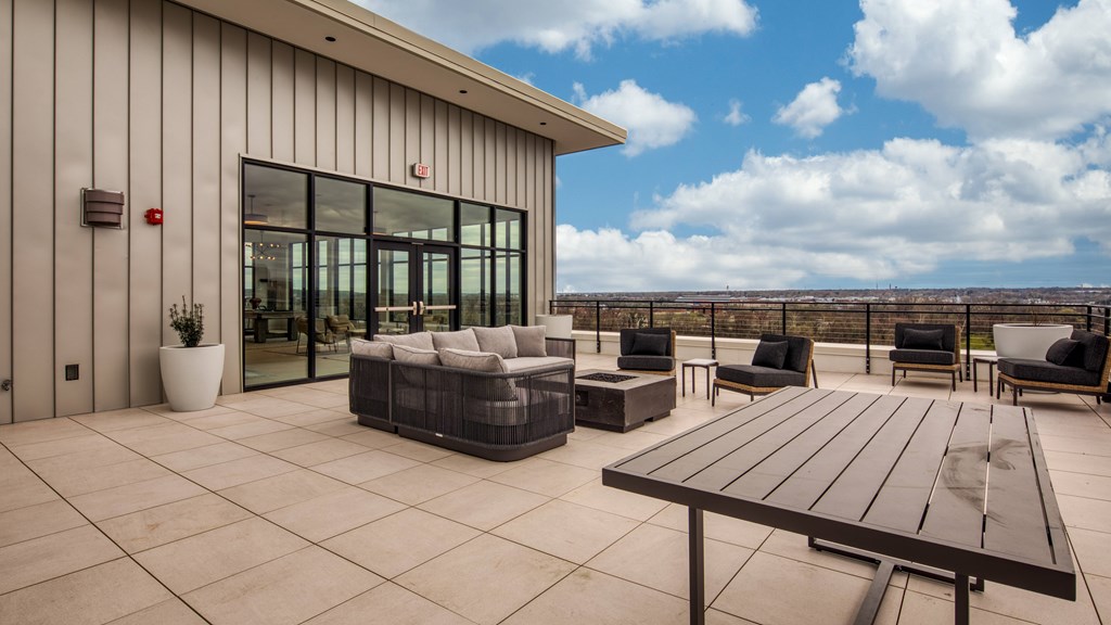 A modern outdoor patio area with a wooden table and chairs.
