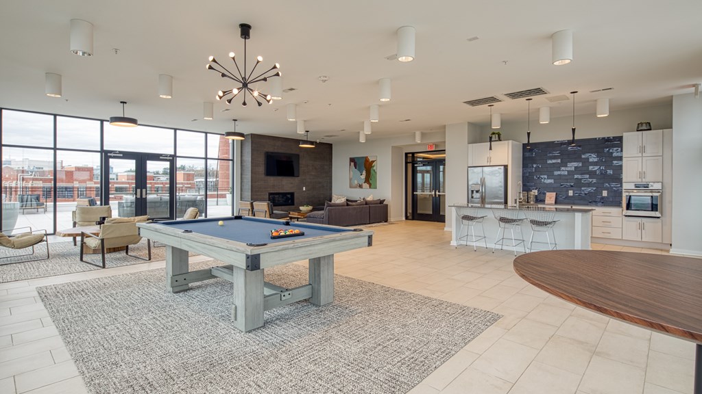 A spacious room with a pool table and bar area.
