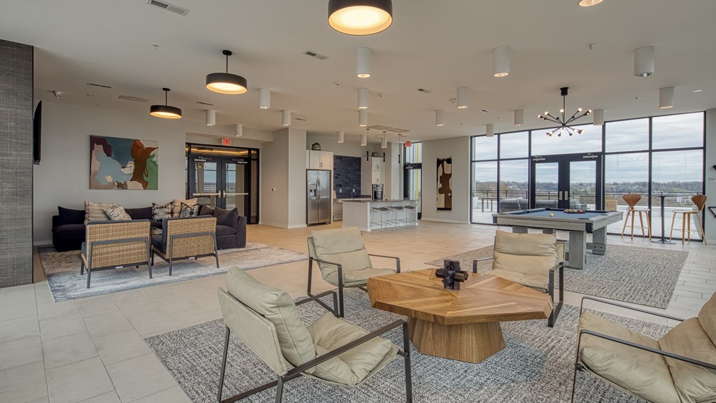 A spacious living room with a large window overlooking the water.