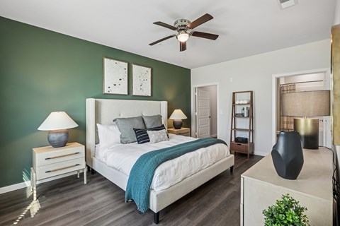 A bedroom with a bed, nightstands, and a ceiling fan.