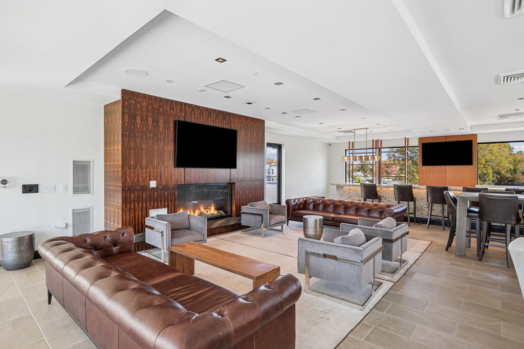 A modern living room with a fireplace and a large leather couch.