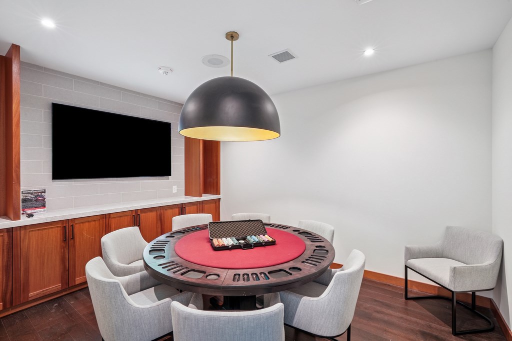 A modern dining room with a round table and grey chairs.