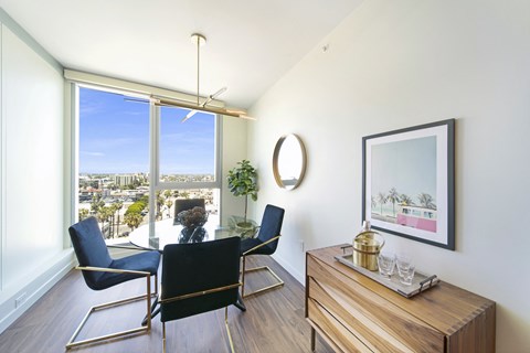 a dining room with a table and chairs and a large window with a view of the city