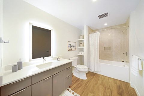 a bathroom with white walls and a wooden floor