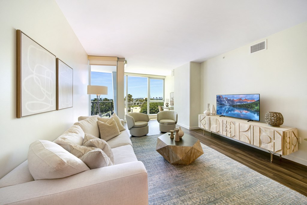 a living room with a white couch and chairs and a flat screen tv