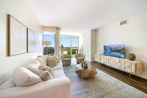 a living room with a white couch and chairs and a flat screen tv