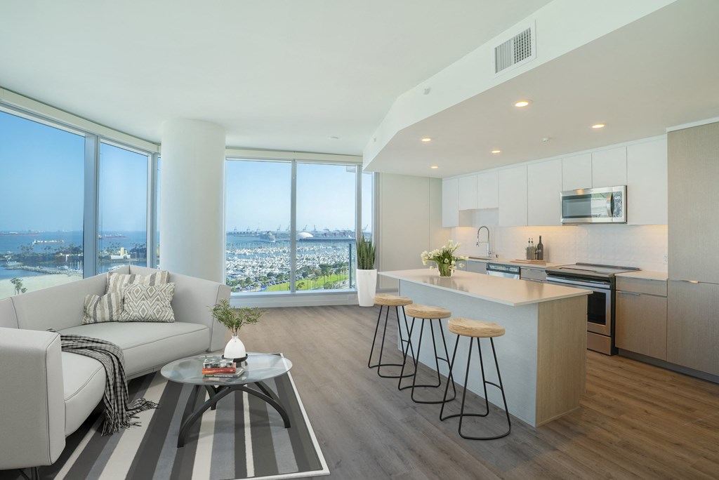 a living area with a sofa coffee table and a kitchen with an island
