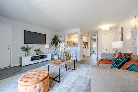 A living room with a grey couch and a white entertainment center.