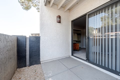 A patio area with a sliding glass door leading to a dining area.