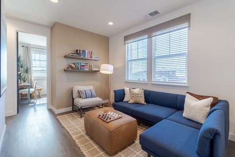 A living room with a blue couch and a wooden coffee table.