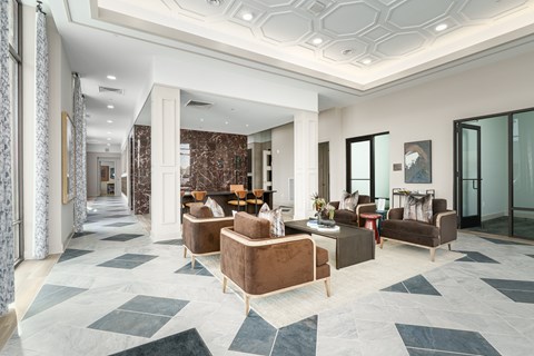 A spacious living room with a patterned carpet and brown furniture.