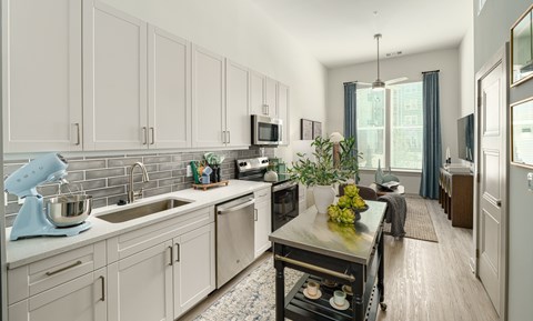 A kitchen with a blue mixer and a black stove.