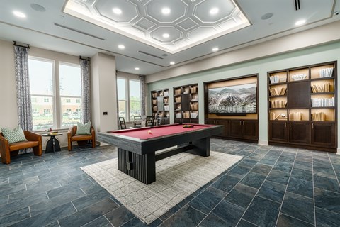 A room with a pool table and a picture of a mountain on the wall.