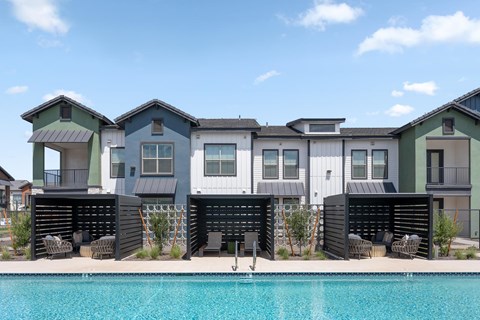 A row of modern houses with a pool in front.
