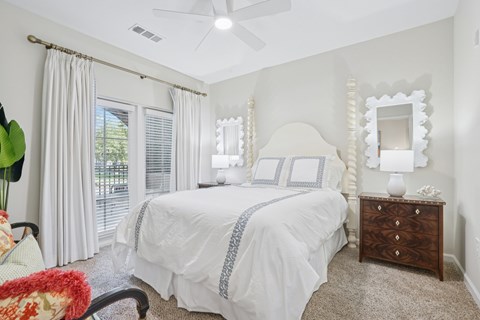 A bedroom with a bed, dresser, and mirror.
