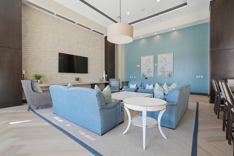 A modern living room with a blue sofa and a white coffee table.