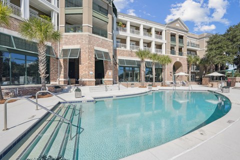 A large swimming pool in front of a multi-story building.