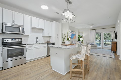 A modern kitchen with white cabinets and stainless steel appliances.