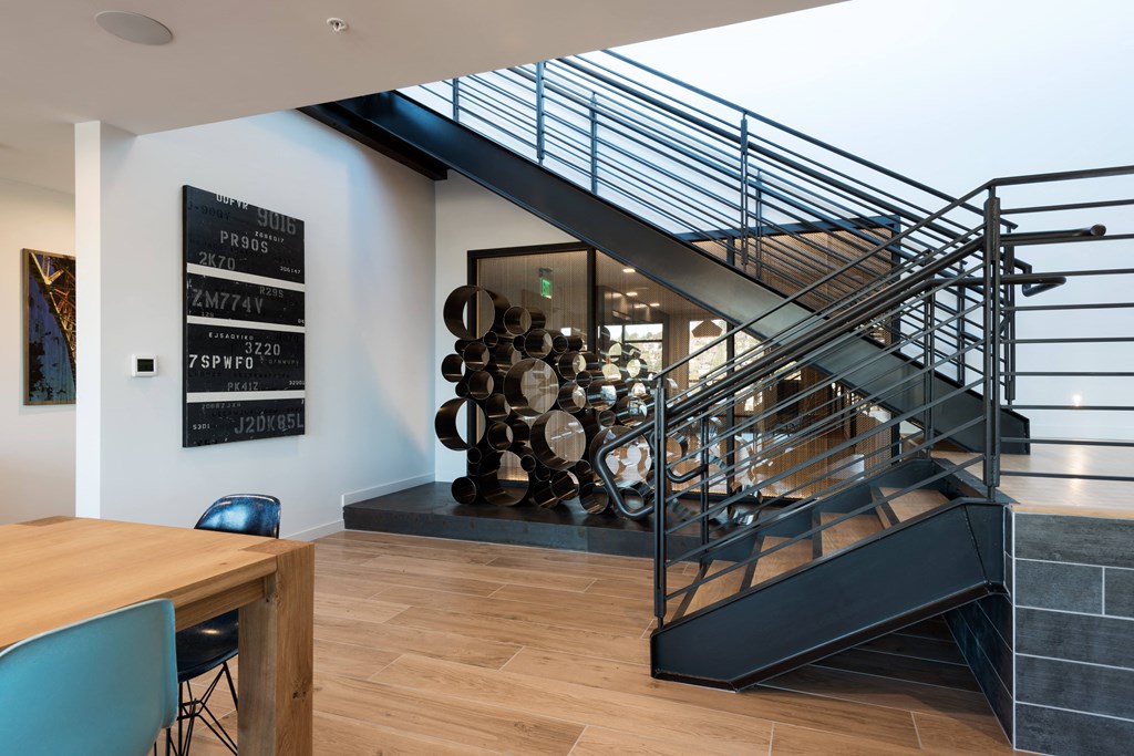 A modern staircase with a metal railing and wooden steps.at Axle, Seattle Washington