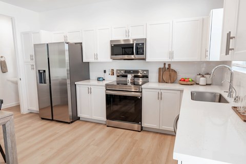 A kitchen with white cabinets and stainless steel appliances.