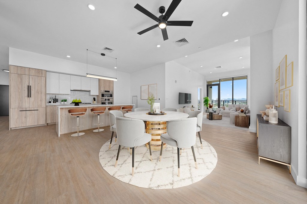 Skye on 6th living room and dining room with a table and chairs, ceiling fan, ceiling lighting, wall decor