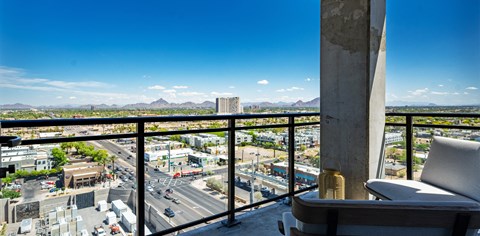 a balcony with a view of the city and a chair