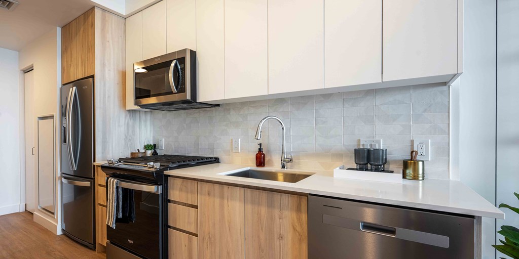 a kitchen with white countertops and wooden cabinets