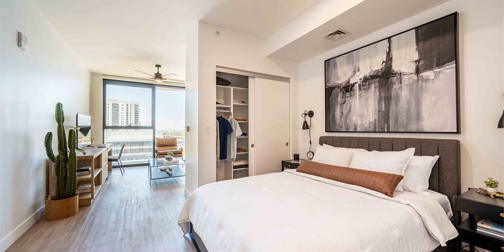 a bedroom with a large bed and a desk with a chair