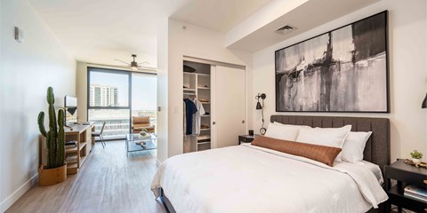 a bedroom with a large bed and a desk with a chair