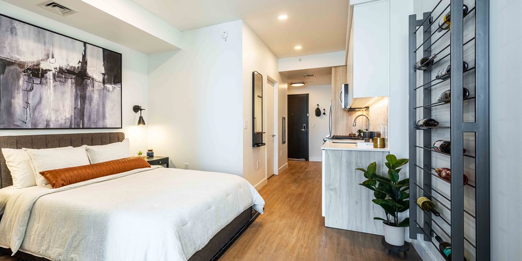 a bedroom with a bed and a desk in a room