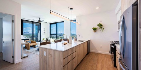 a kitchen with a large center island next to a living room