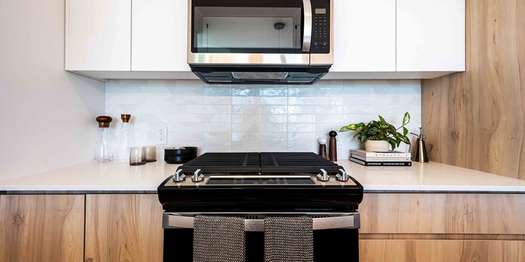 a kitchen with white cabinets and a black stove top oven