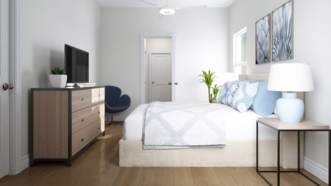 A bedroom with a bed, a chair, a nightstand, and a television.